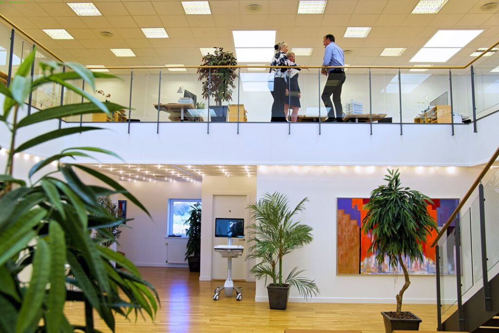 Moderne kontor med medarbejdere og grønne planter