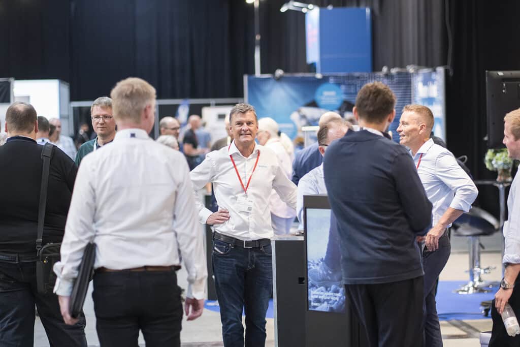 Mennesker netværker på messe i udstillingshal