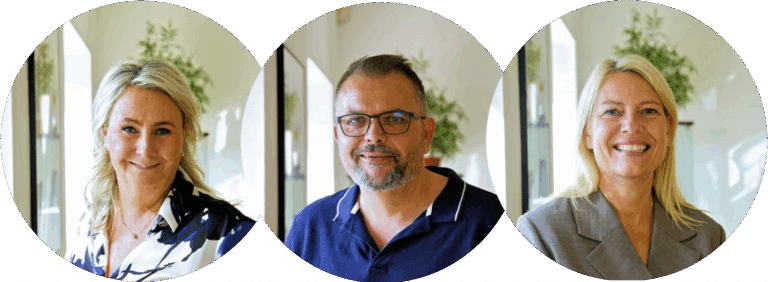 Tre smilende kolleger på kontor
